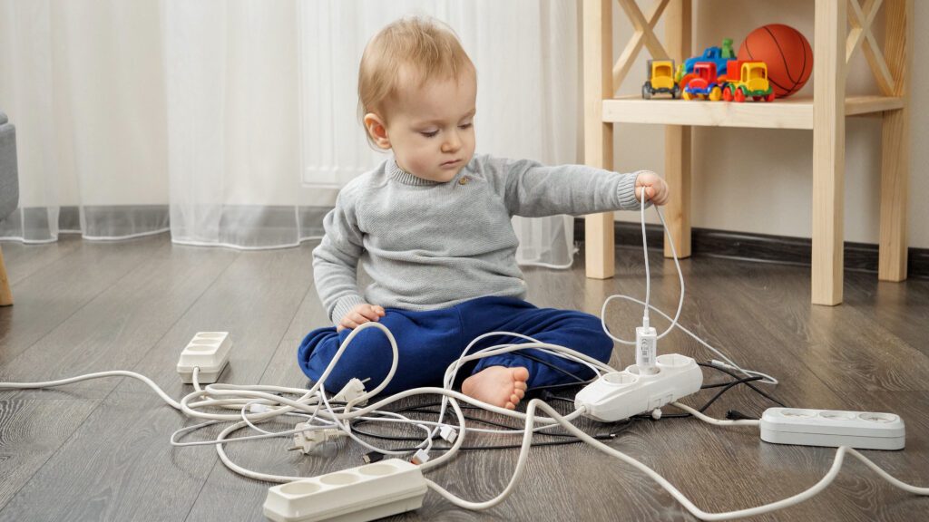 kid playing with extension sockets Keeping kids safe from electrical hazards
